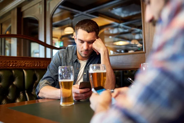 スマート フォンでビールを飲むと男性バーやパブ — ストック写真