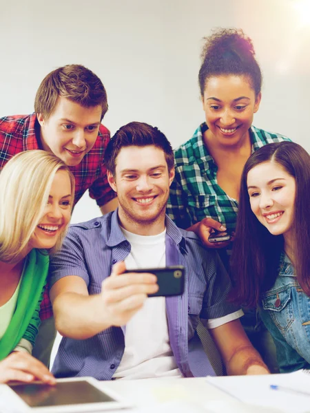 Studenten op zoek naar smartphone op school — Stockfoto