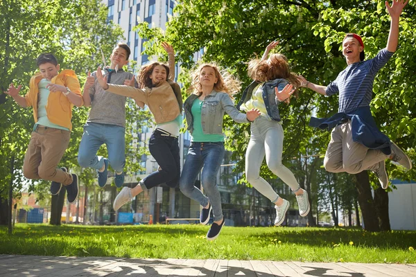 快乐的青少年学生或朋友在户外跳 — 图库照片