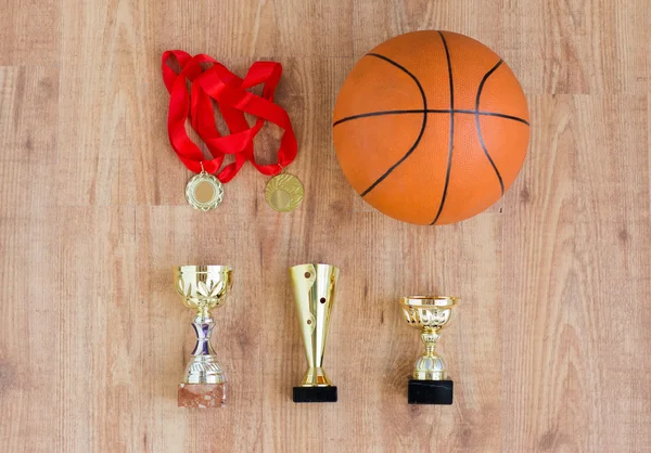 Basketbalová koule s poháry a zlatými metály — Stock fotografie