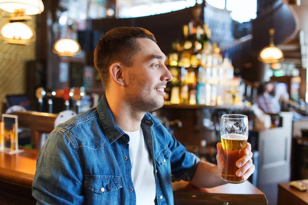 Homem feliz bebendo cerveja no bar ou pub — Fotografia de Stock