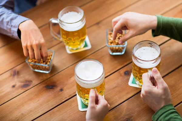 Fermer les mains avec des tasses à bière au bar ou au pub — Photo