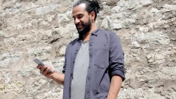 Человек смс сообщение на смартфоне на каменной стене 5 — стоковое видео
