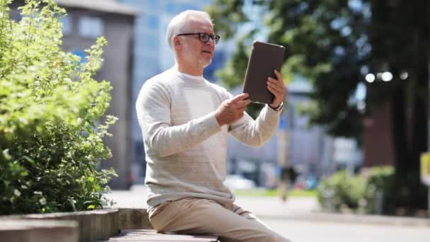 Hombre mayor que tiene videollamada en la tableta PC en la ciudad — Vídeos de Stock