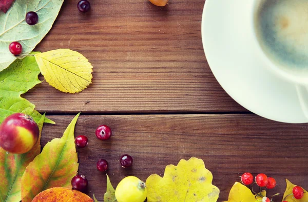 Zamknij się z filiżanki kawy na stole z liści jesienią — Zdjęcie stockowe