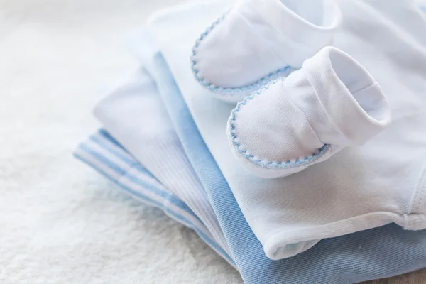 Primer plano de la ropa de los niños del bebé para el recién nacido en la mesa —  Fotos de Stock