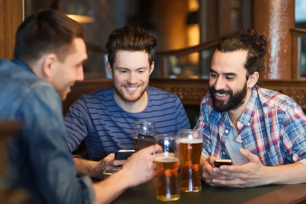 スマート フォンでビールを飲むと男性の友達バー — ストック写真