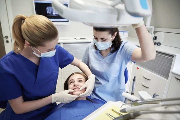 Heureuse femme dentiste avec patient fille à la clinique — Photo