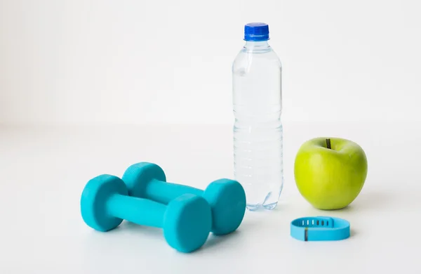 Dumbbells, fitness tracker, apple and bottle — Stock Photo, Image