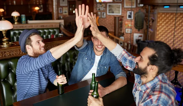 Men with beer making high five at bar or pub — Stock Photo, Image