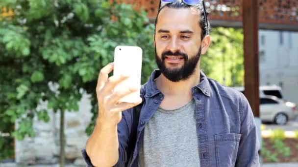 Мужчина снимает видео или селфи на смартфон в городе 42 — стоковое видео
