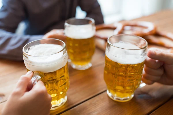 Fermer les mains avec des tasses à bière au bar ou au pub — Photo