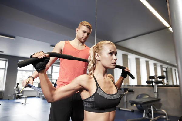 Hombres y mujeres flexionando los músculos en la máquina de gimnasio —  Fotos de Stock