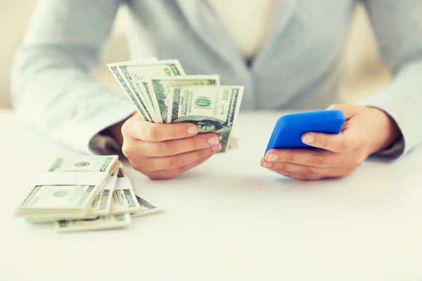 Close up de mãos de mulher com smartphone e dinheiro — Fotografia de Stock
