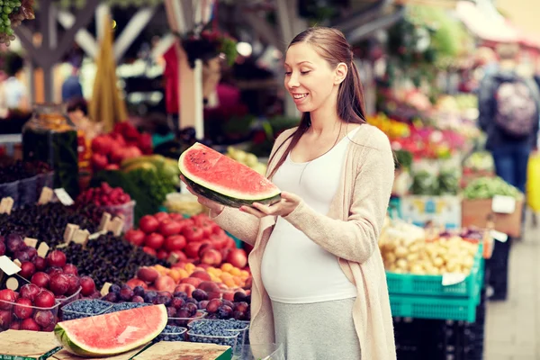 Femme enceinte tenant pastèque au marché de rue — Photo