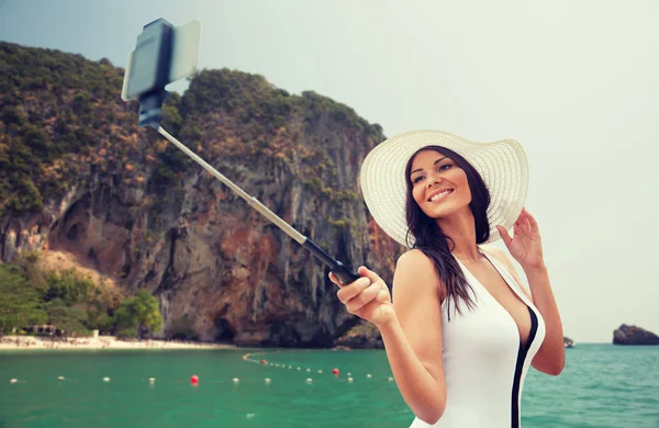 幸福的女人，在海滩上采取与智能手机拍照 — 图库照片