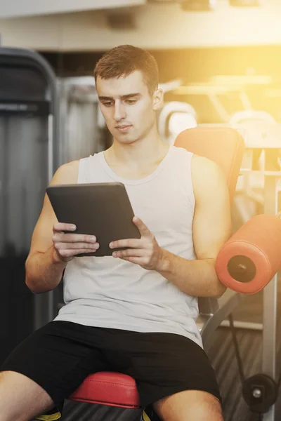 Young man with tablet pc computer in gym — Stock Photo, Image