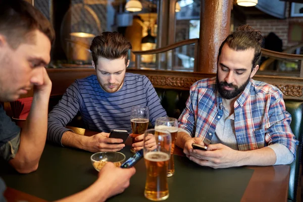 Άνδρες με smartphones πίνοντας μπύρα στο μπαρ ή παμπ — Φωτογραφία Αρχείου
