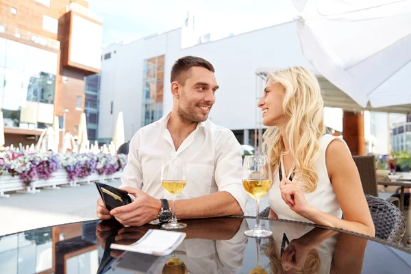 Casal feliz com carteira pagar conta no restaurante — Fotografia de Stock