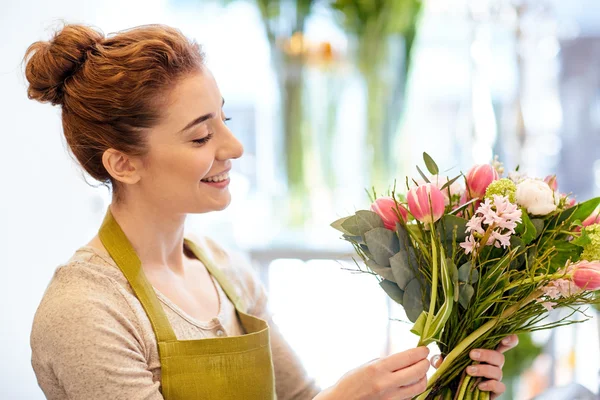 Sonriente florista mujer haciendo ramo en floristería —  Fotos de Stock