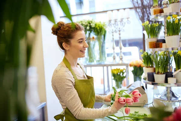 Sonriente florista mujer haciendo ramo en floristería —  Fotos de Stock