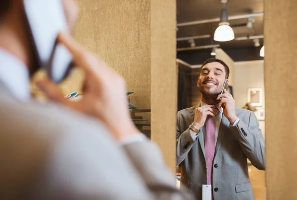 Muž na smartphone na oděvy obchod zrcadlo — Stock fotografie