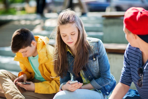 Amigos adolescentes con teléfonos inteligentes al aire libre —  Fotos de Stock