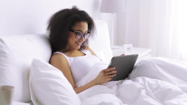 African woman with tablet pc in bed at home — Stock Video