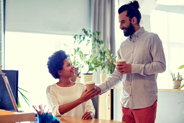 Uomo felice che porta il caffè alla donna in ufficio — Foto Stock