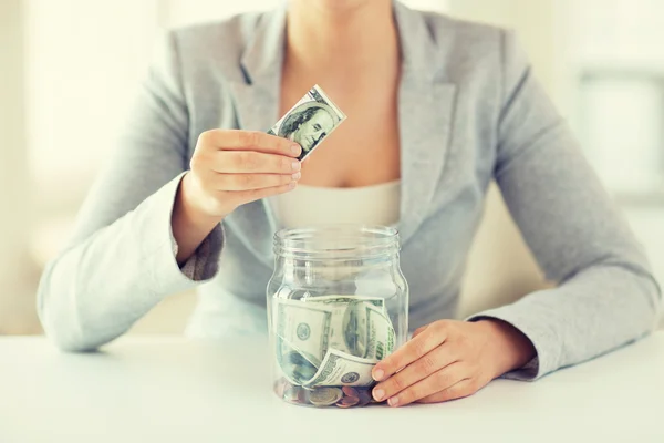 Close up of woman hands and dollar money in jar — Stock Photo, Image