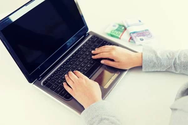 Close up de mãos de mulher com laptop e dinheiro — Fotografia de Stock