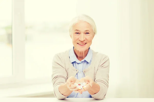 Счастливая пожилая женщина с медициной дома — стоковое фото