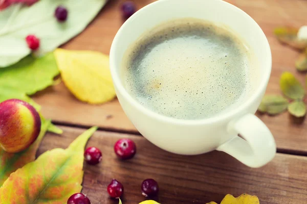 Close up de xícara de café na mesa com folhas de outono — Fotografia de Stock