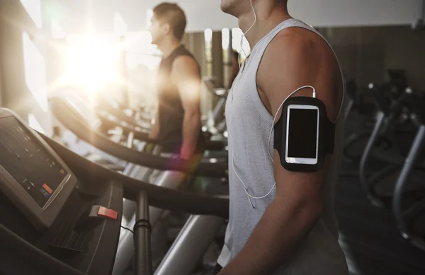 close up of man with smartphone in gym