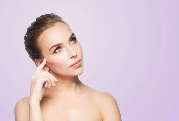 Beautiful young woman touching her face — Stock Photo, Image