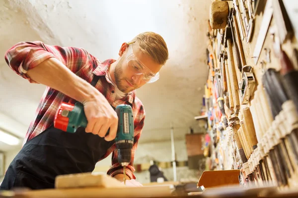 Timmerman met boor boren plank op workshop — Stockfoto