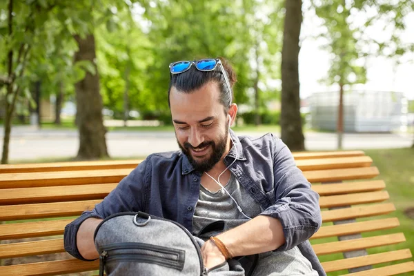 Man met rugzak en oortelefoons in stad — Stockfoto