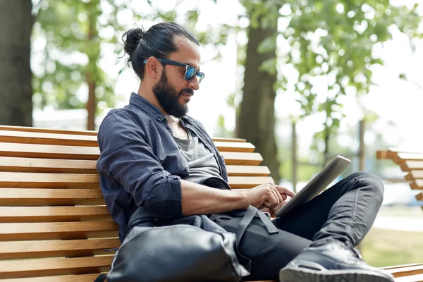 Mann mit Tablet-PC sitzt auf Stadtbank — Stockfoto