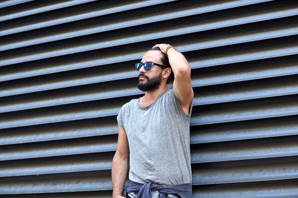 Uomo con barba e occhiali da sole sulla strada della città — Foto Stock