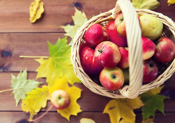 Close up of basket with apples on wooden table Stock Photo