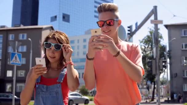 Feliz casal adolescente com smartphones na cidade — Vídeo de Stock