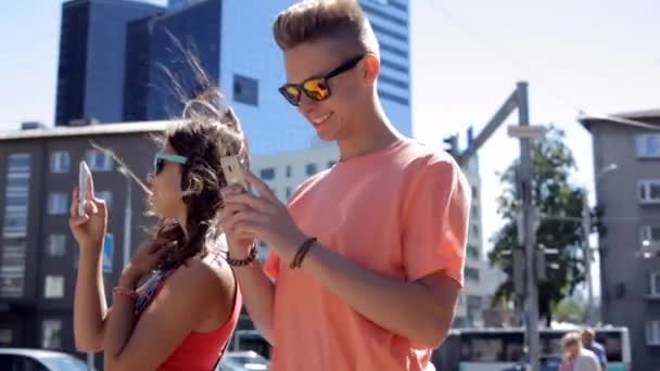 Ευτυχισμένο εφηβικό ζευγάρι με smartphones στην πόλη — Αρχείο Βίντεο