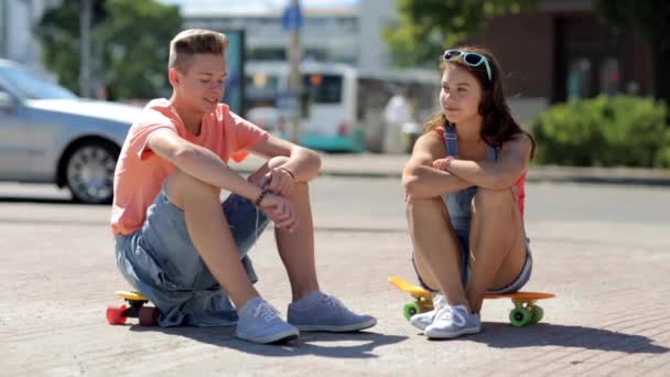 Tiener paar met penny planken praten in de stad — Stockvideo