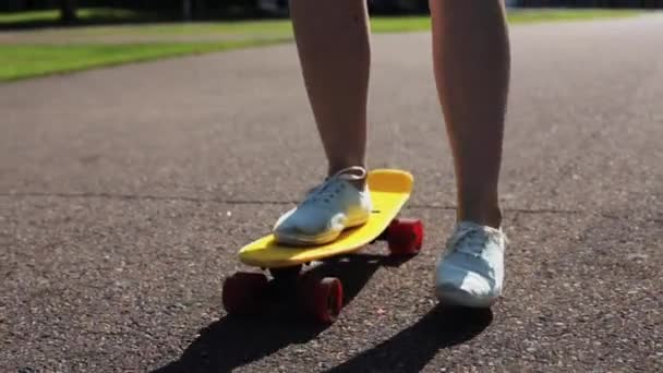 Teenage girl feet riding short modern skateboard — Stock Video