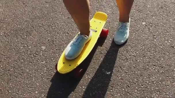 10 代の少女の足短い現代スケート ボードに乗って — ストック動画
