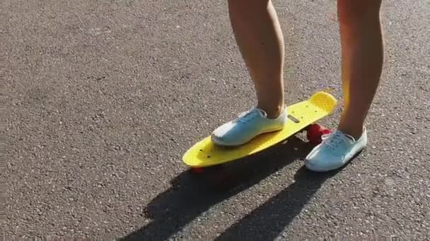 Подростковые ноги верхом на коротком современном скейтборде — стоковое видео