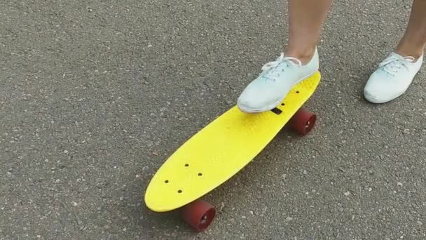 Adolescent fille toot mettre court skateboard sur le bout — Video