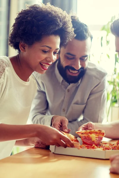 Equipe de negócios feliz comer pizza no escritório — Fotografia de Stock