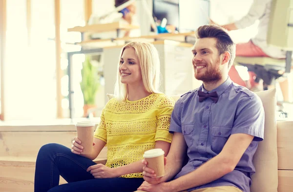 Lycklig man och kvinna dricker kaffe i office — Stockfoto