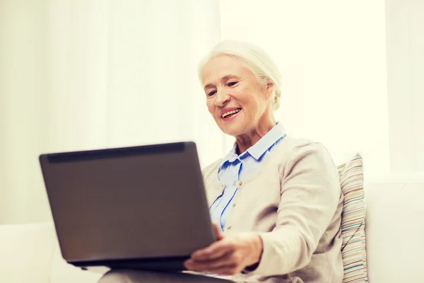 Mulher sênior feliz com laptop em casa — Fotografia de Stock